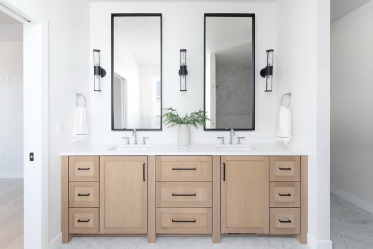 Oak double vanity with two black-framed mirrors