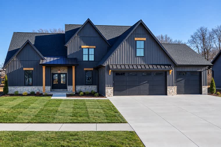 Navy two-story home with board-and-batten siding and a three-car garage