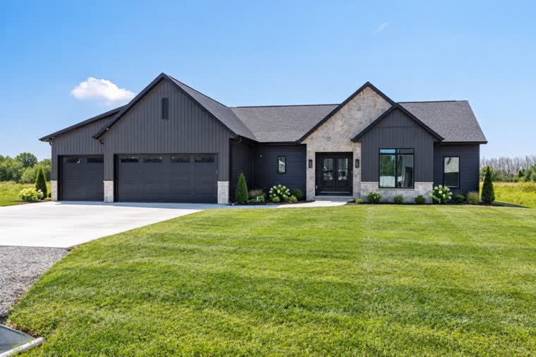 Charcoal ranch home with a stone entry and a three-car garage