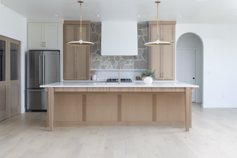 Kitchen with an oak island, a stone backsplash and a white range hood
