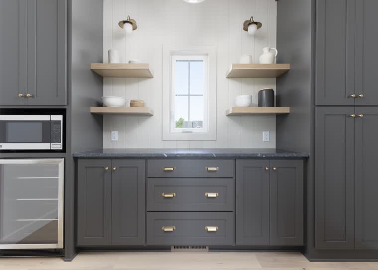 Butler pantry with charcoal cabinets, oak floating shelves and a beverage fridge