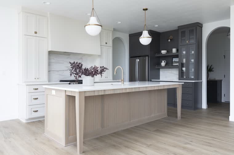 Kitchen with an oak island, white perimeter cabinets and a charcoal coffee bar