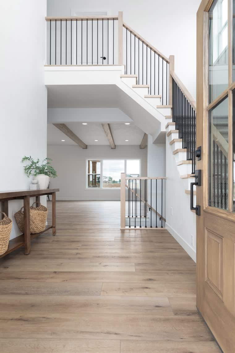Two-story entry with an open staircase and a wood front door
