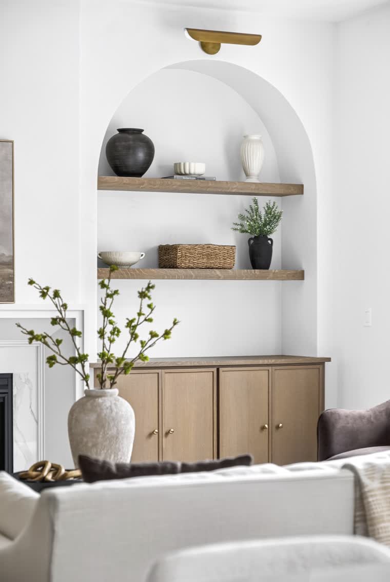 Arched wall niche with floating shelves above an oak cabinet